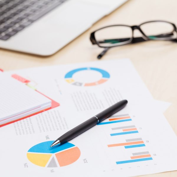 Office desk workplace with laptop and reports